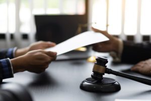 A close-up of a judge's desk with an attorney holding papers.