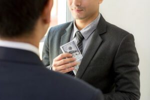 a businessman putting money in his suit