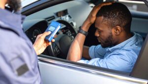 Officer conducting breathalyzer test at a DUI checkpoint.