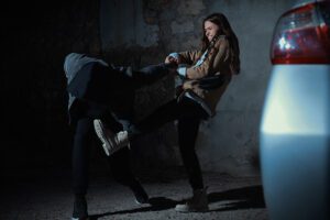 Woman defending herself from attacker in parking lot.